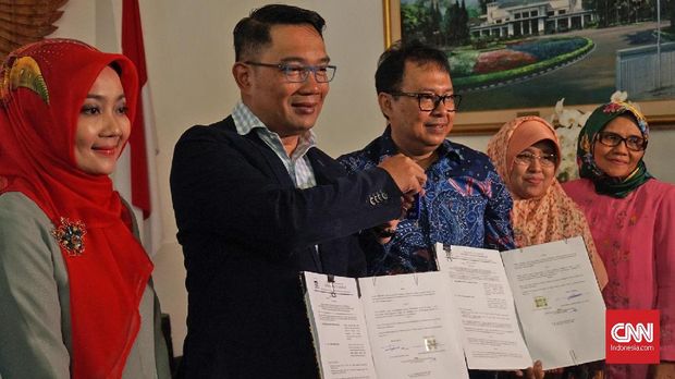 Wali Kota Bandung Ridwan Kamil (tengah) didampingi keluarga menunjukkan surat serah terima fasilitas negara dengan Sekretaris Daerah Kota Bandung Yossi Irianto (kedua kanan) di Rumah Dinas Pendopo, Bandung, Jawa Barat, Sabtu (20/1).